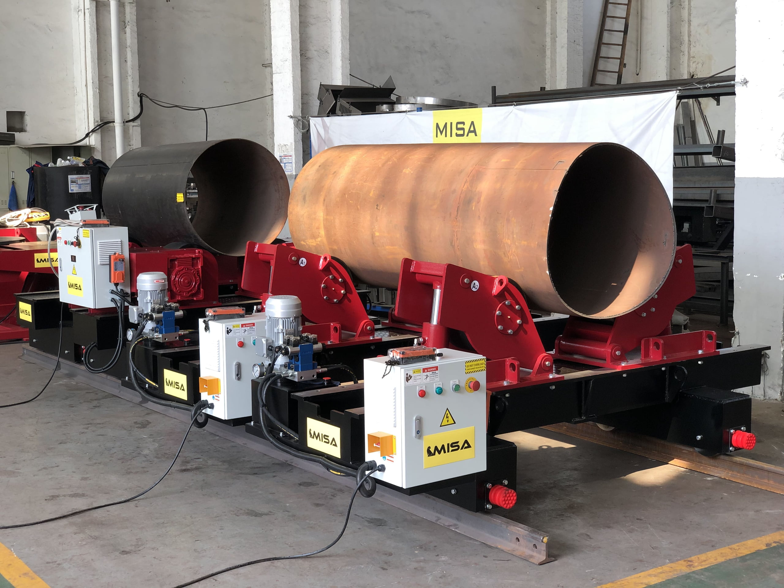 Large cylindrical vessel positioned on welding rotators in a fabrication workshop